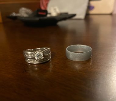 challenges of being a caregiver | Sanfilippo News | Two wedding rings sit side-by-side on a wooden table. On the left is Valerie's white gold wedding band with a diamond, and on the right is her silver-colored silicon ring she wears during the summer.